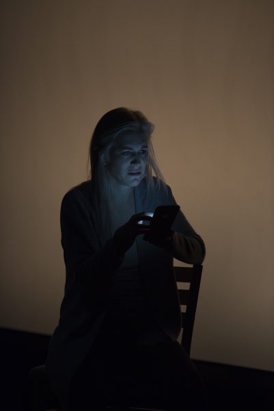 a blond woman holds a cell phone